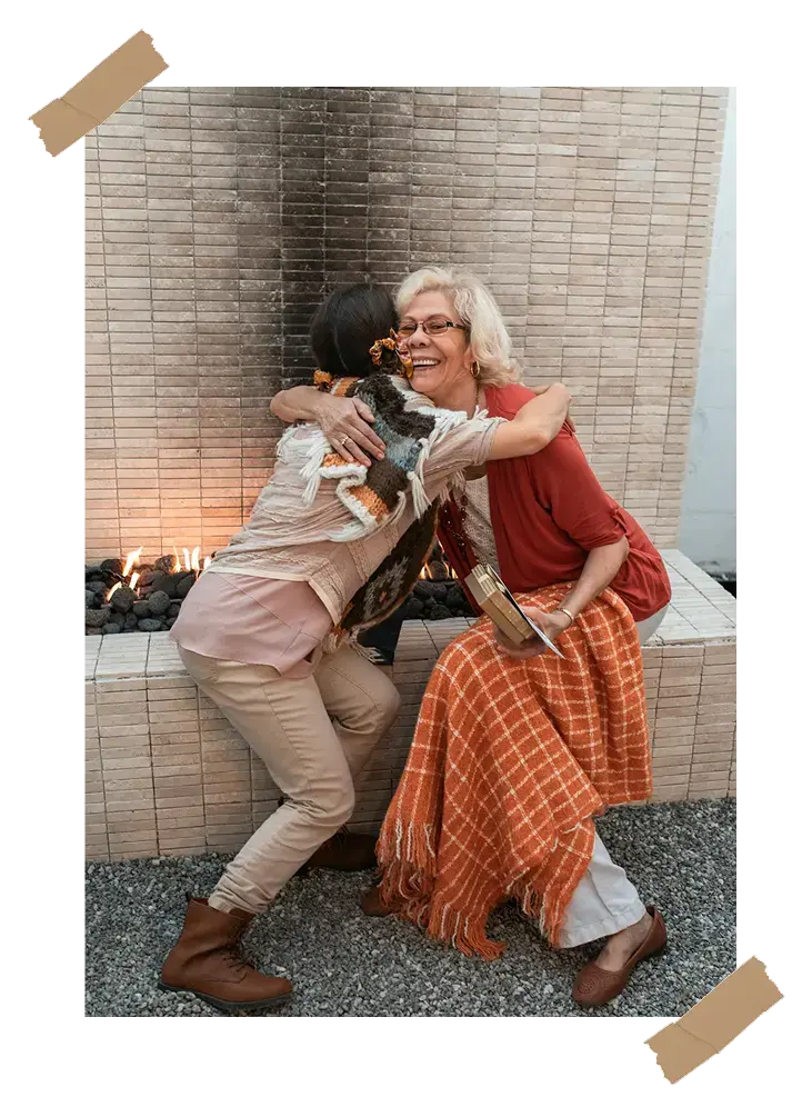 A touching moment between grandmother and granddaughter, showing a life story book as a personalized gift for grandma to share their life stories - LifeScript.
