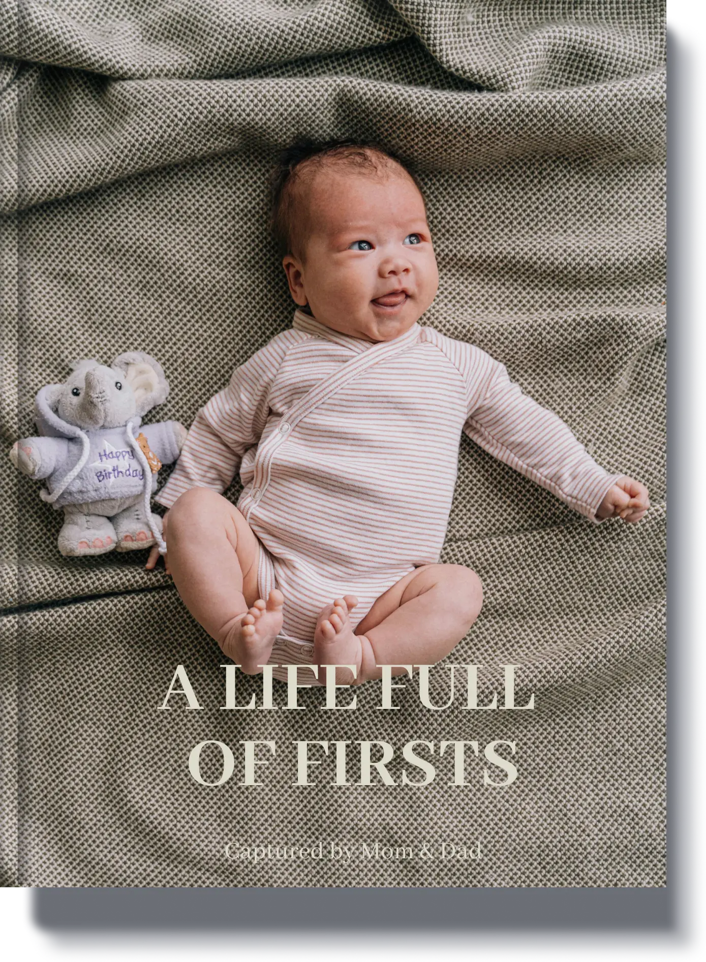 A Life Full of Firsts - A childhood memory book capturing a baby’s earliest milestones, featuring a newborn lying on a cozy blanket with a stuffed elephant.