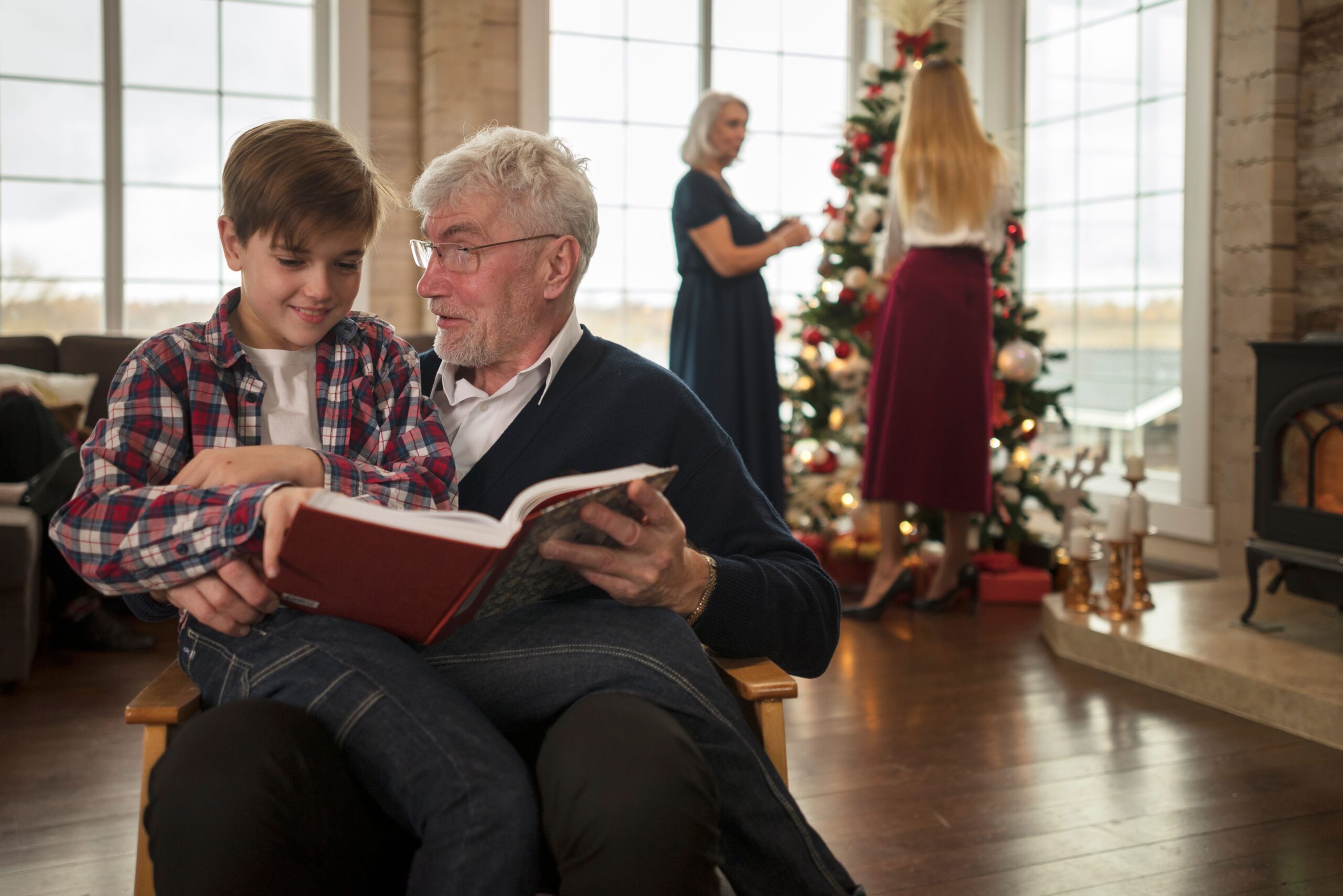 grandpa reading a book with grandson during Christmas